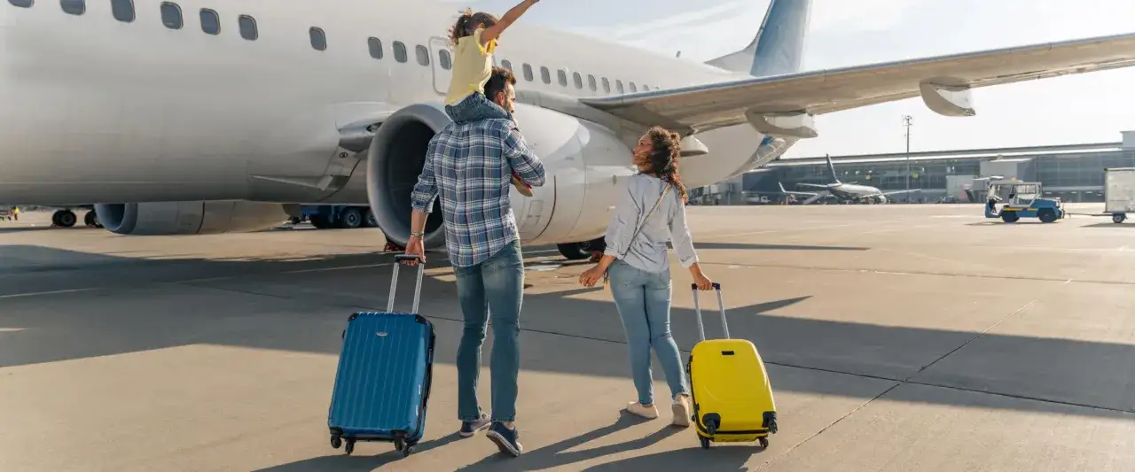 Rodzina z walizkami na lotnisku Radom. Jakie linie latają z Radomia? Wkrótce się przekonamy!