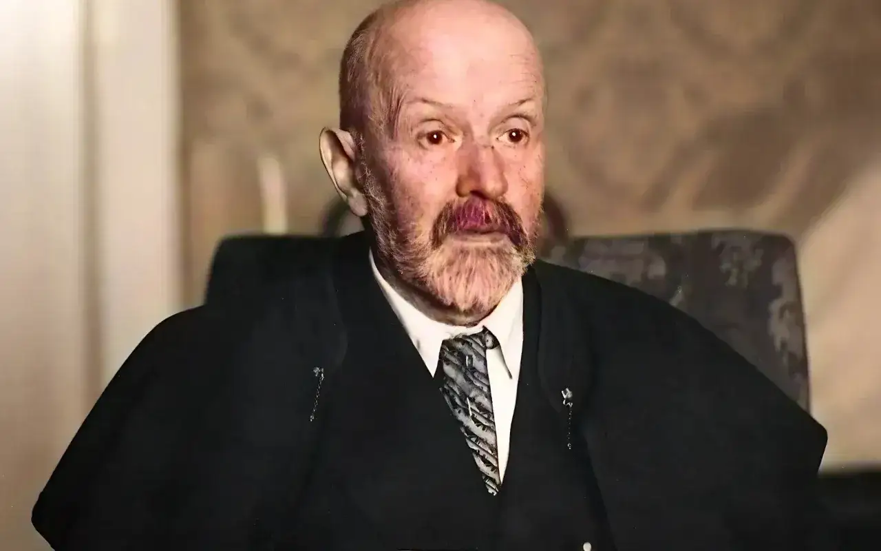 Portret starszego mężczyzny z siwą brodą i wąsami, w garniturze i krawacie. Jego spojrzenie jest intensywne, jakby uchwycone w chwili głębokiej refleksji nad rzeczywistością. Malczewski w swoim żywiole.