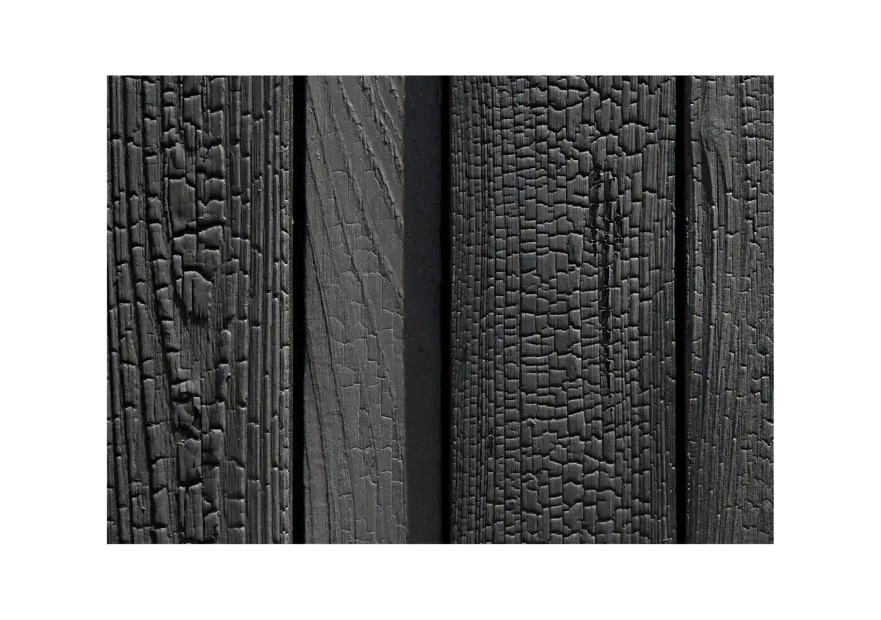 Szare, spękane deski z opalanej drewna tworzą unikalną teksturę.