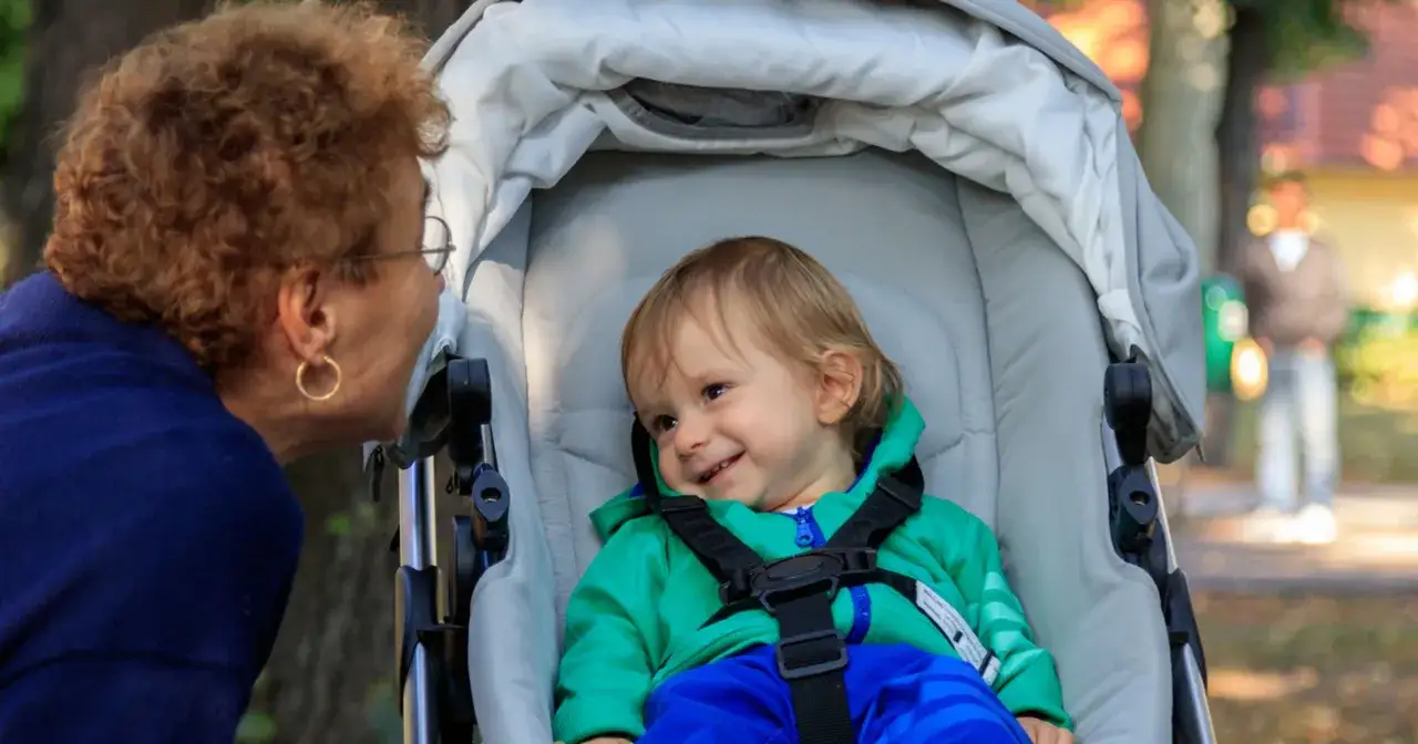 Babcia rozmawia z wnukiem w wózku. Ciekawe, ile bierze niania za godzinę, żeby zapewnić taką troskę.
