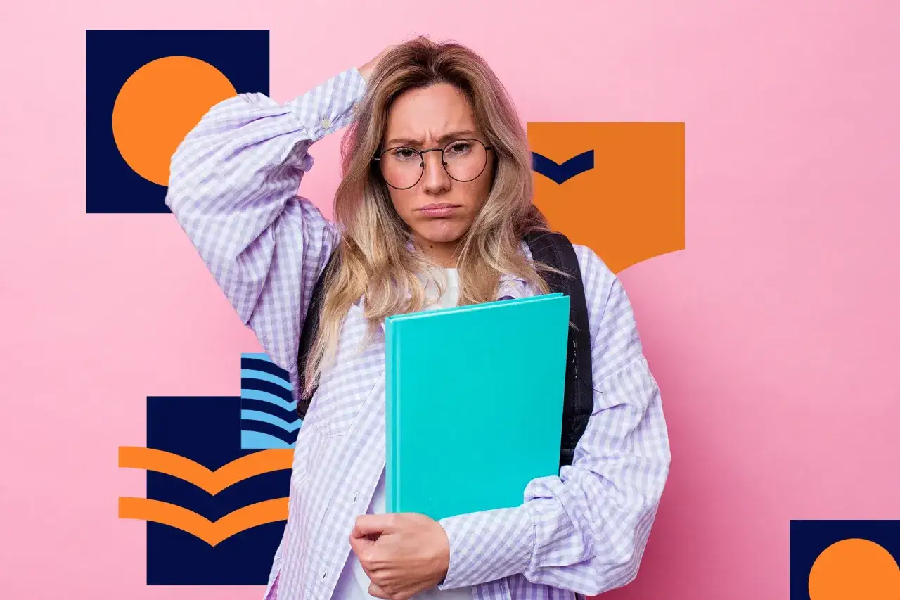 Zmartwiona uczennica w okularach trzyma książkę na tle różowej ściany z geometrycznymi wzorami.