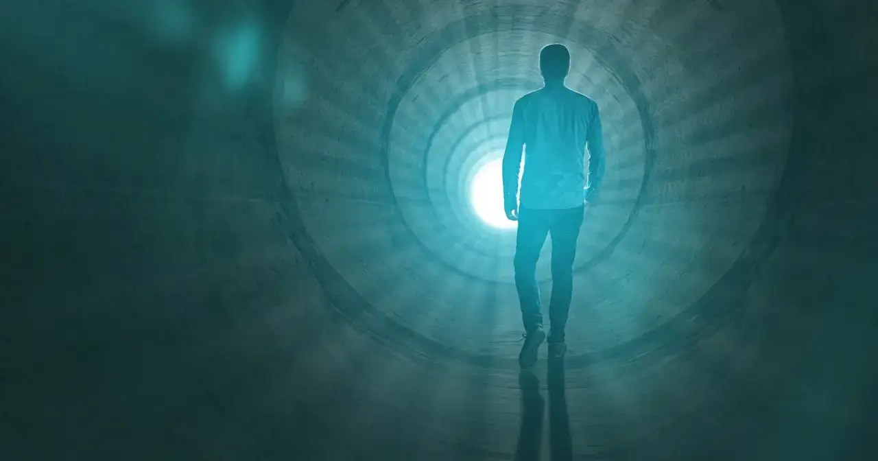 Człowiek idzie w stronę światła w tunelu, symbolizującym to, co się dzieje po śmierci.