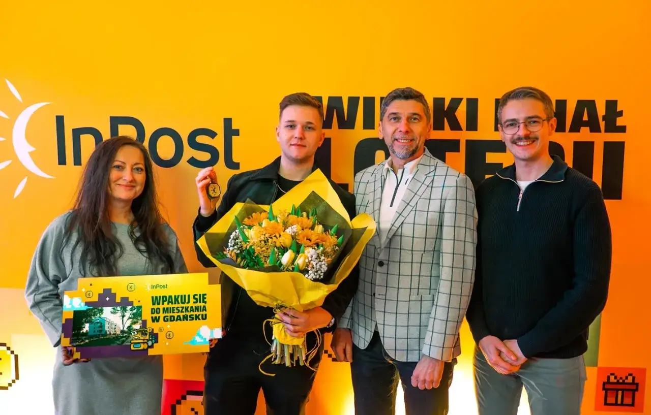 Szczęśliwiec, kto wygrał mieszkanie w loterii InPost, odbiera klucze i bukiet.