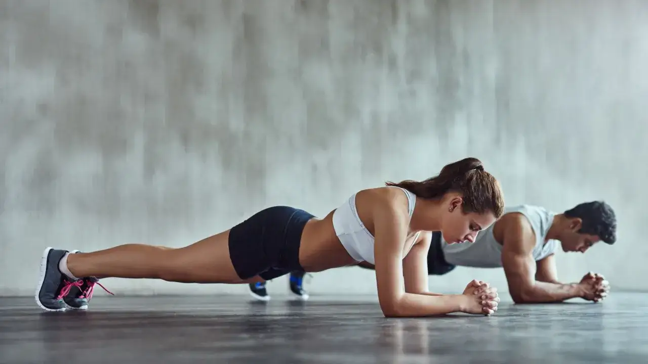 Para ćwiczy plank, co to trening core. Wzmacniają mięśnie brzucha i pleców.