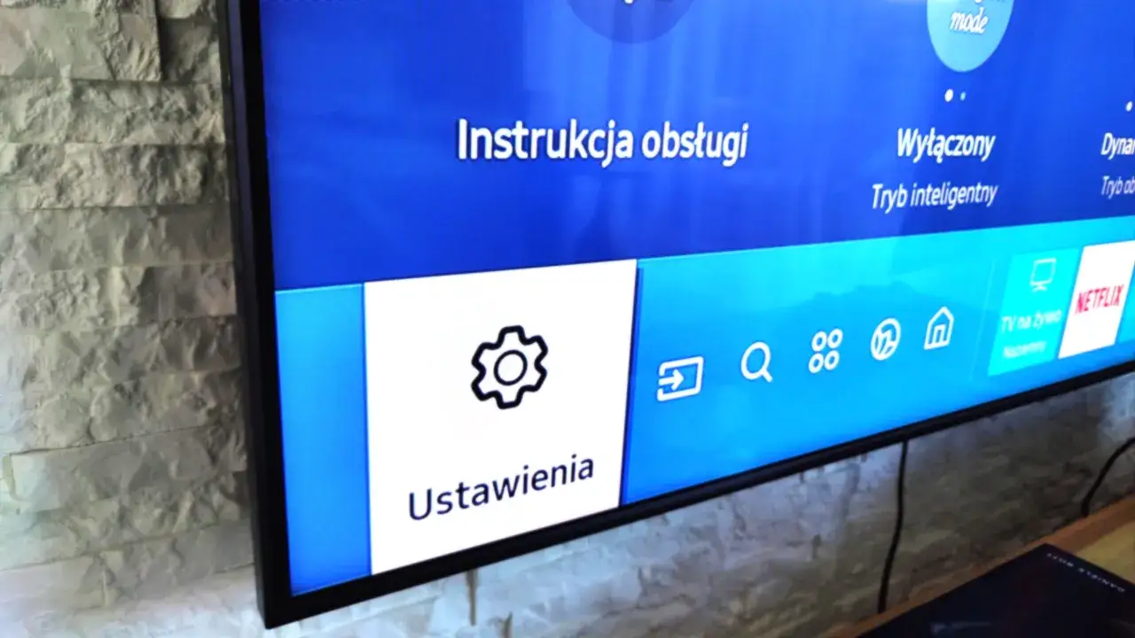 Ekran telewizora Samsung z menu Ustawienia i ikoną koła zębatego.