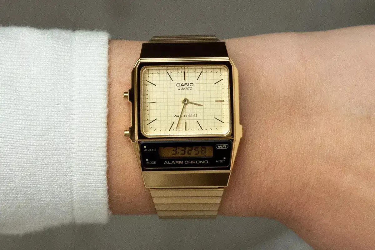 Złoty zegarek Casio na damskim nadgarstku, z analogową tarczą i cyfrowym wyświetlaczem.