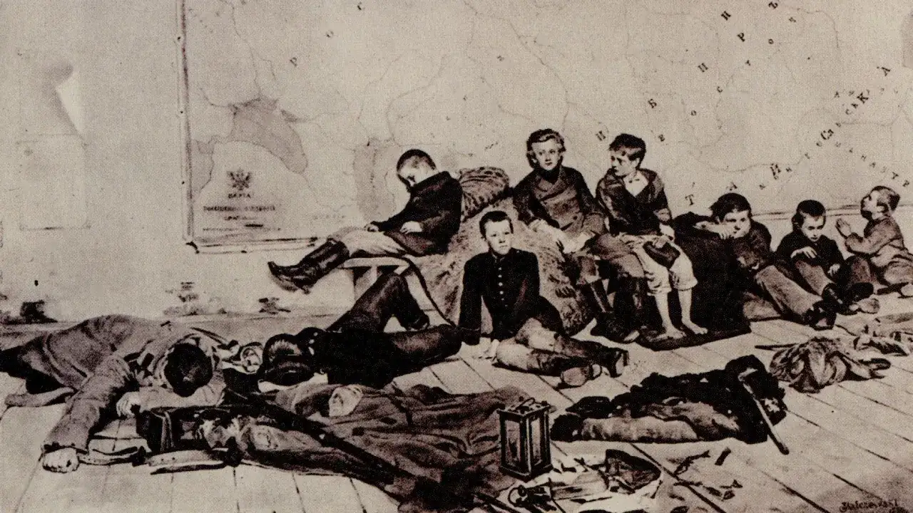 Grupa chłopców w strojach z epoki siedzi i leży na podłodze obok mapy.