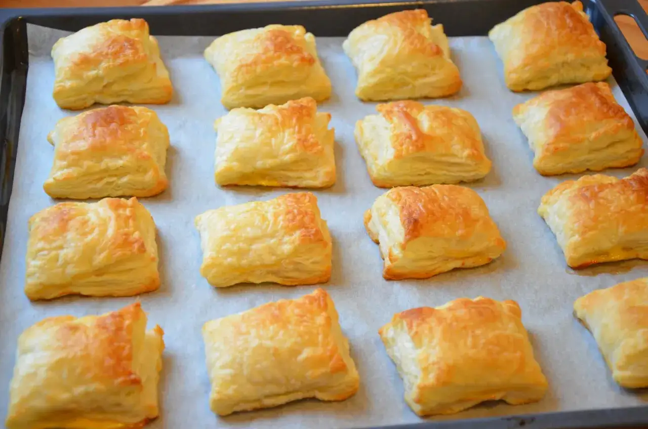 Pieczone kwadratowe ciastka francuskie na blasze.