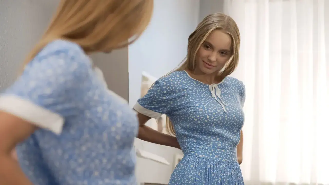 Młoda kobieta w kwiecistej sukience, uosobienie stylu lat 30. moda, przymierza strój przed lustrem.