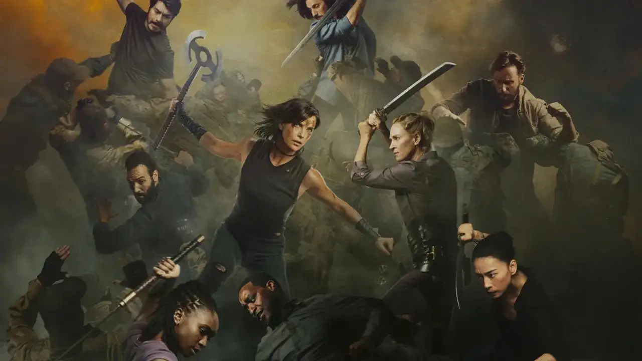 Grupa wojowników walczy w mgle. W centrum dwie kobiety z mieczami, a wokół nich inni walczący. To scena z filmu "The Old Guard 2".