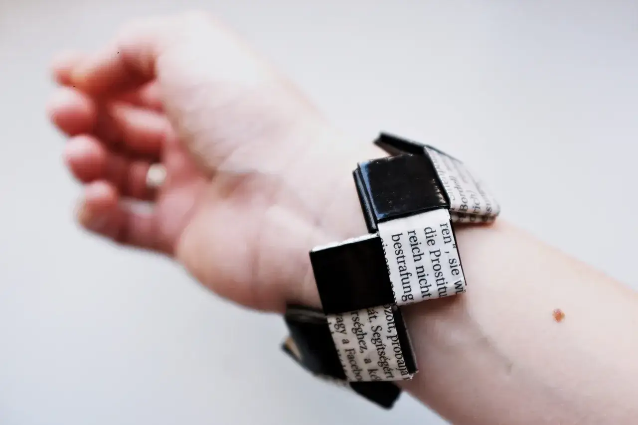 Bransoletka z papieru z tekstem na ręce.