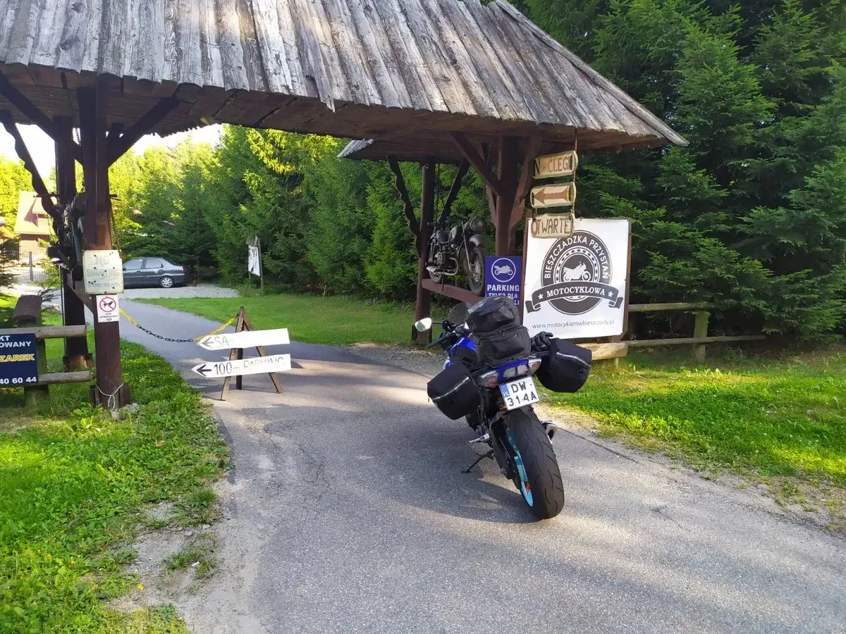 Motocykl czeka na dalszą podróż po Słowacji. Przy drogowskazie "100m parking" i znaku "Bieszczadzka Przystań Motocyklowa" zaczyna się przygoda.