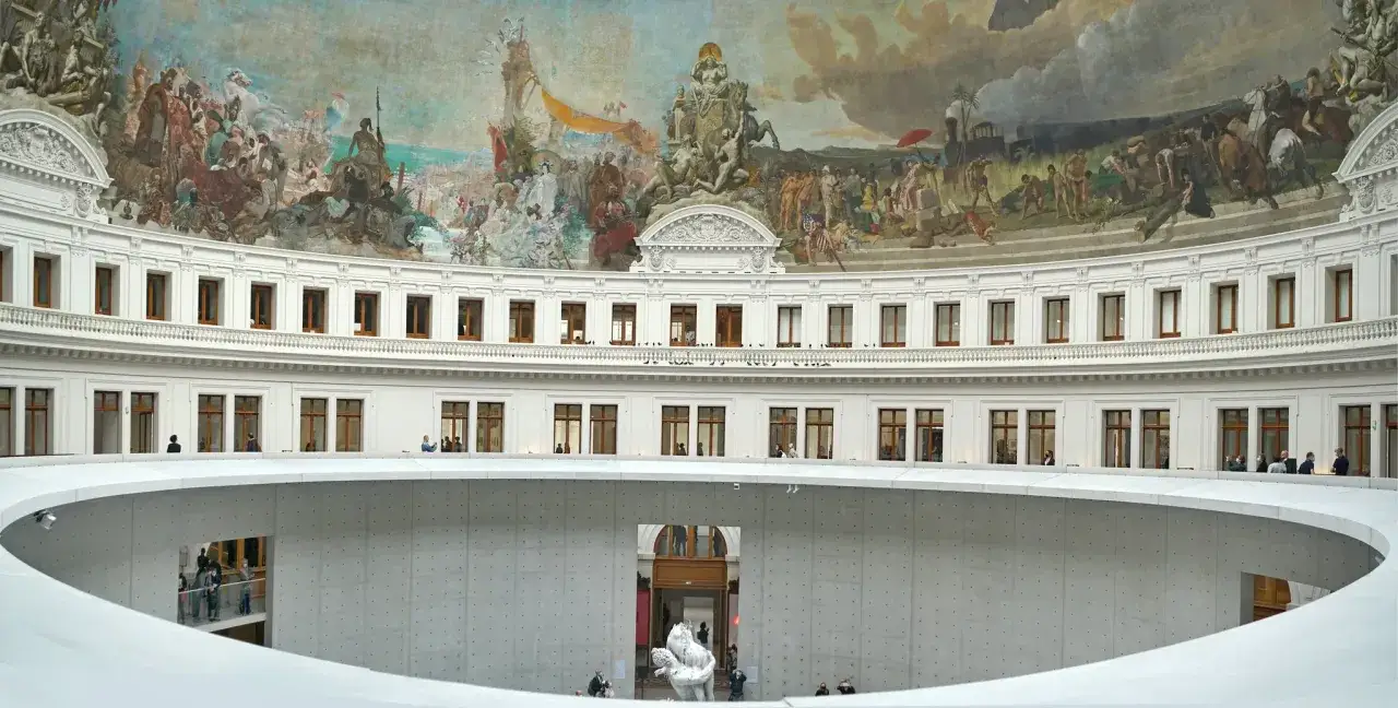 Wnętrze Bourse de Commerce w Paryżu, z freskami na kopule i nowoczesną spiralną rampą. Może to być miejsce, gdzie François Pinault prezentuje swoje kolekcje sztuki.