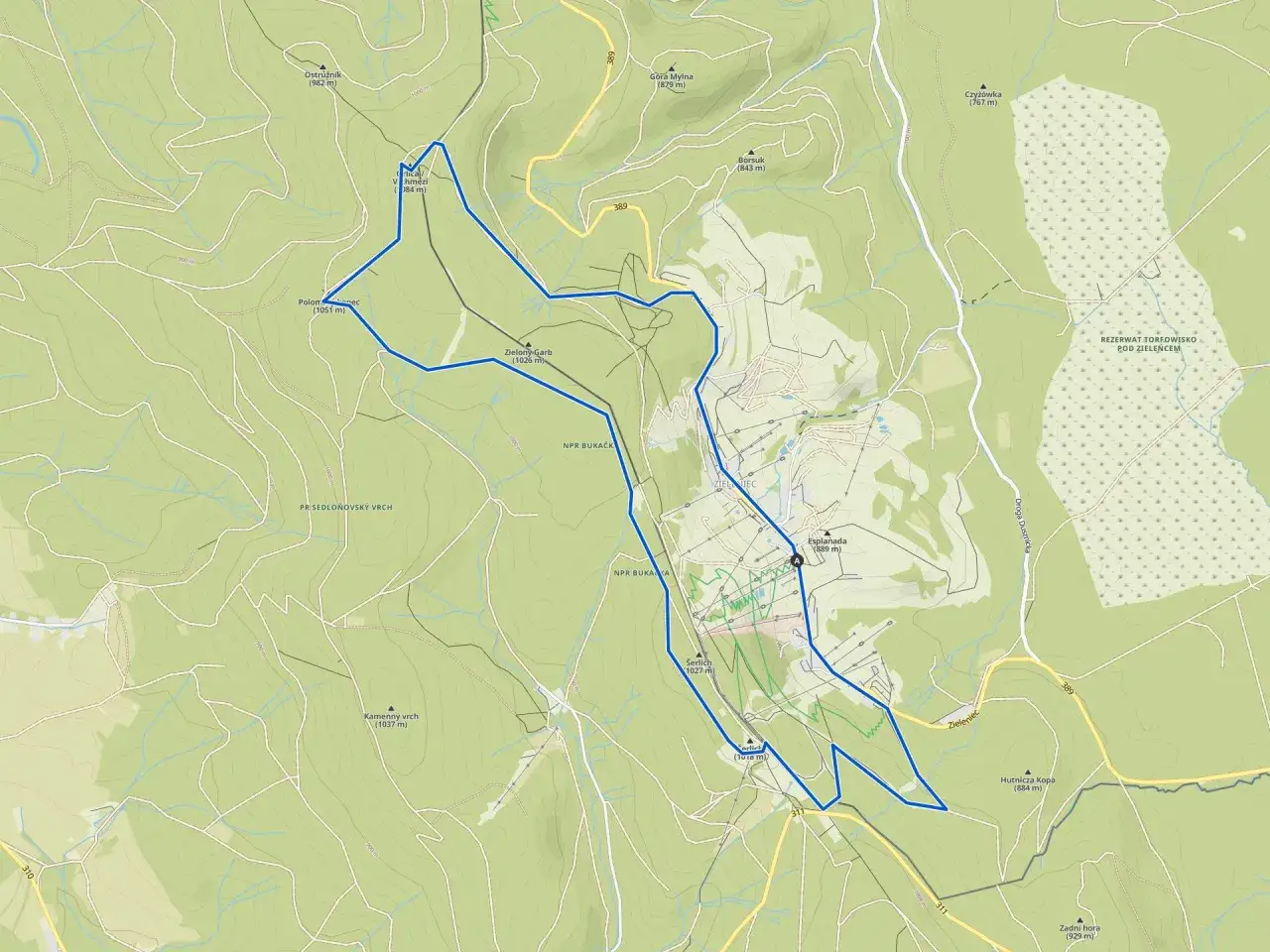Mapa turystyczna okolic Polanicy Zdrój. Widoczne szlaki, wzniesienia (np. Zielony Garb 1026 m, Kamienny vrch 1037 m) i rezerwaty przyrody.