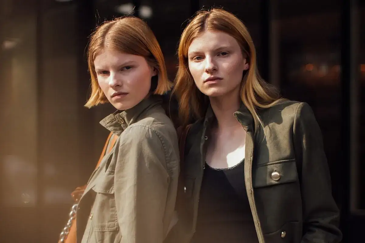 Dwie młode kobiety w militarnych kurtkach, stylizacja nawiązująca do mody lat 80.