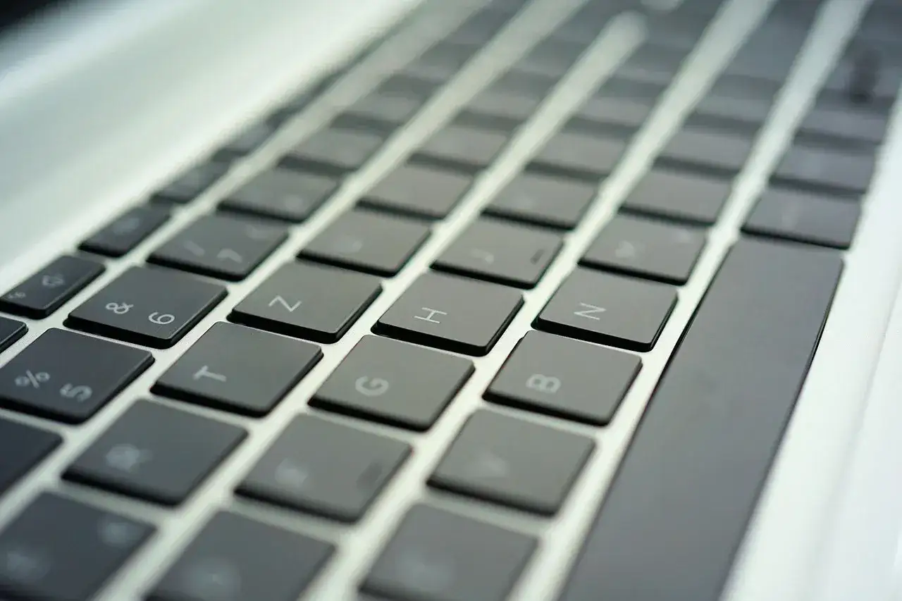 Zbliżenie na klawiaturę laptopa z widocznymi klawiszami liter i cyfr.