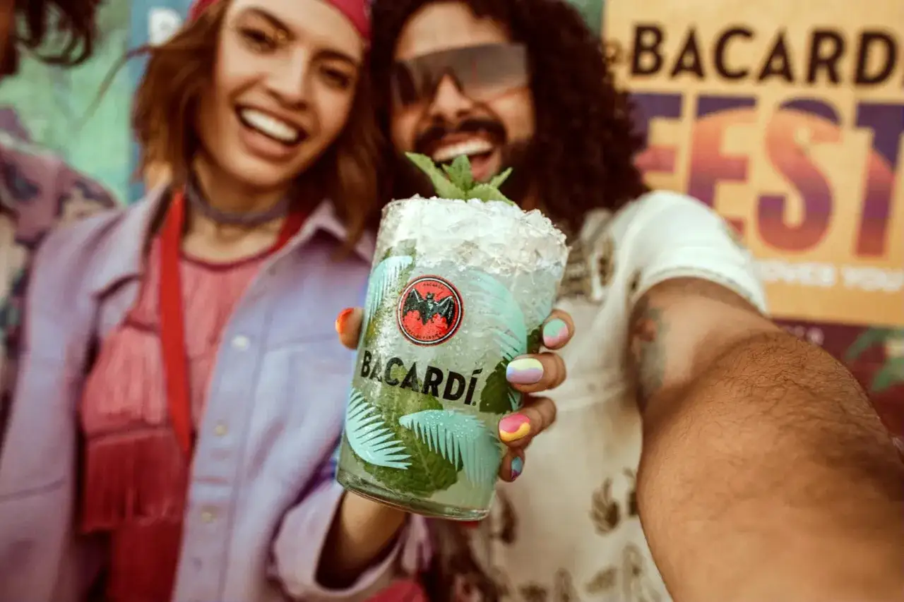 Radosna para świętuje na festiwalu z orzeźwiającym drinkiem Bacardi Mojito.