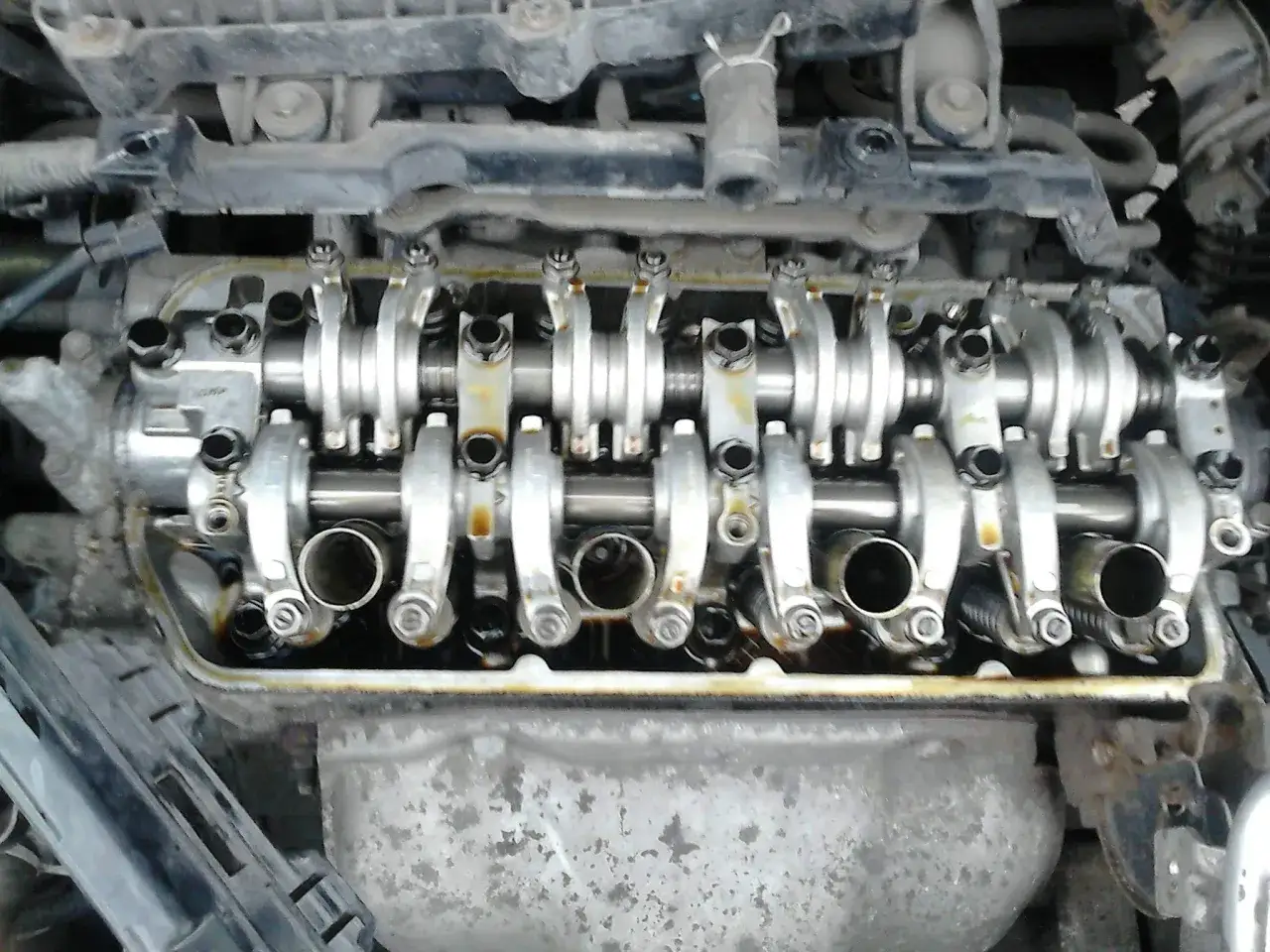 Górna część silnika Hondy Civic 1.6 VTEC z widocznym wałkiem rozrządu i zaworami.