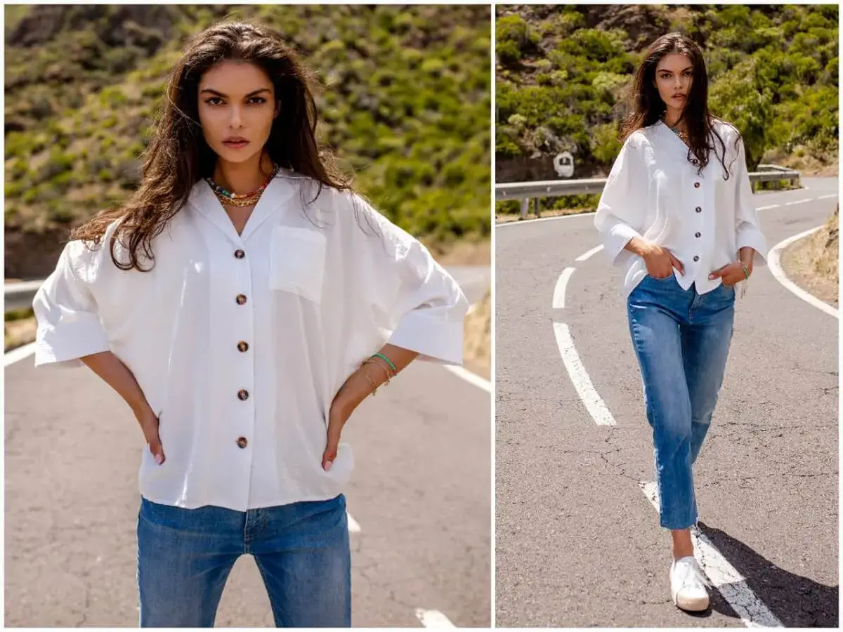 Kobieta w białej koszuli i jeansach na drodze.