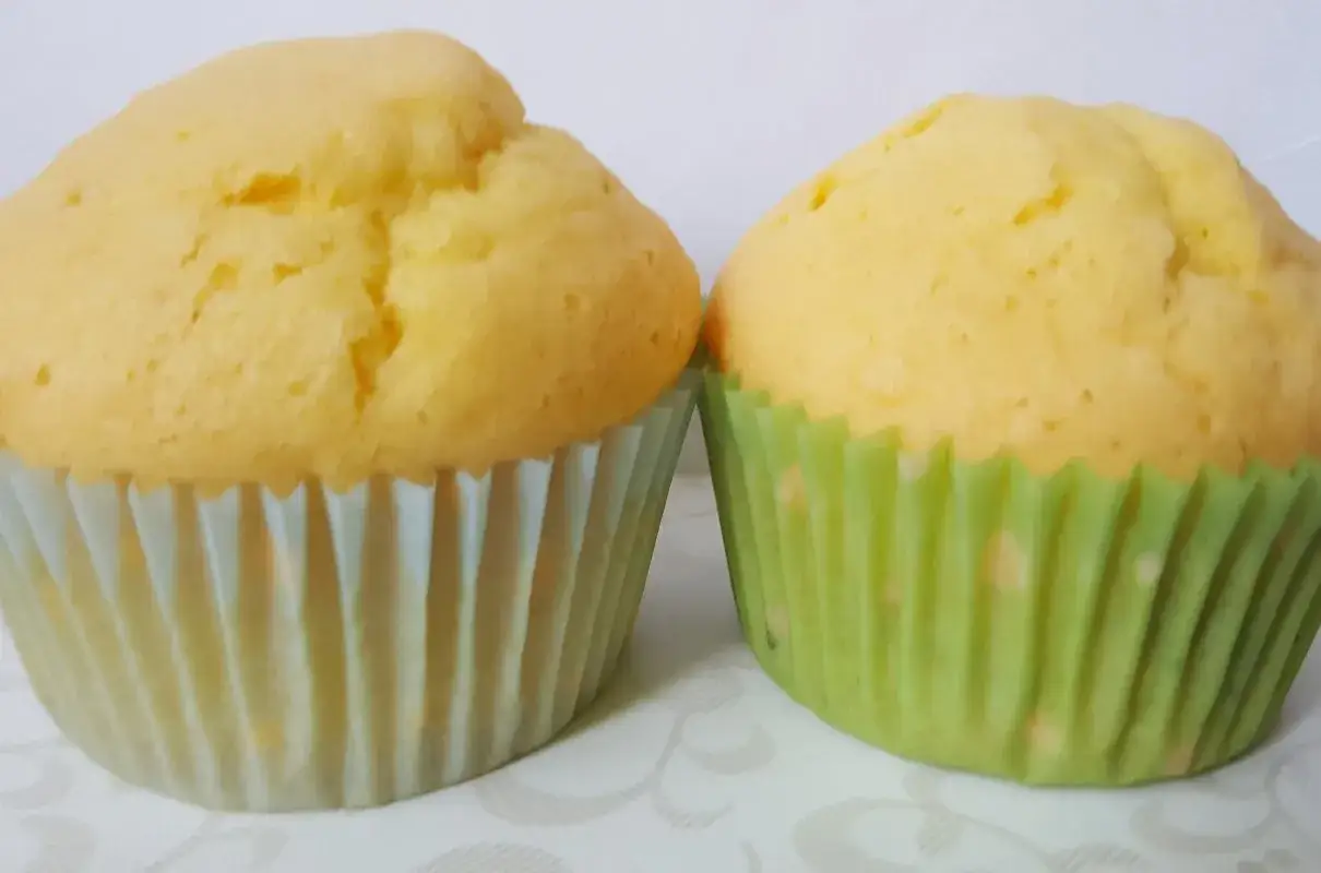 Dwa puszyste babeczki bezglutenowe w papierowych foremkach. Idealne na podwieczorek, gdy szukasz przepisu na babeczki bezglutenowe.