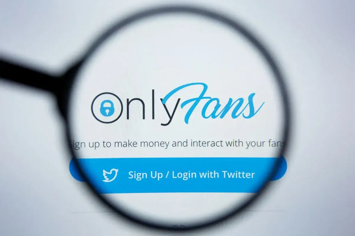 Logo OnlyFans pod lupą. Platforma pozwala zarabiać i wchodzić w interakcje z fanami. Dowiedz się, only fans o co chodzi.