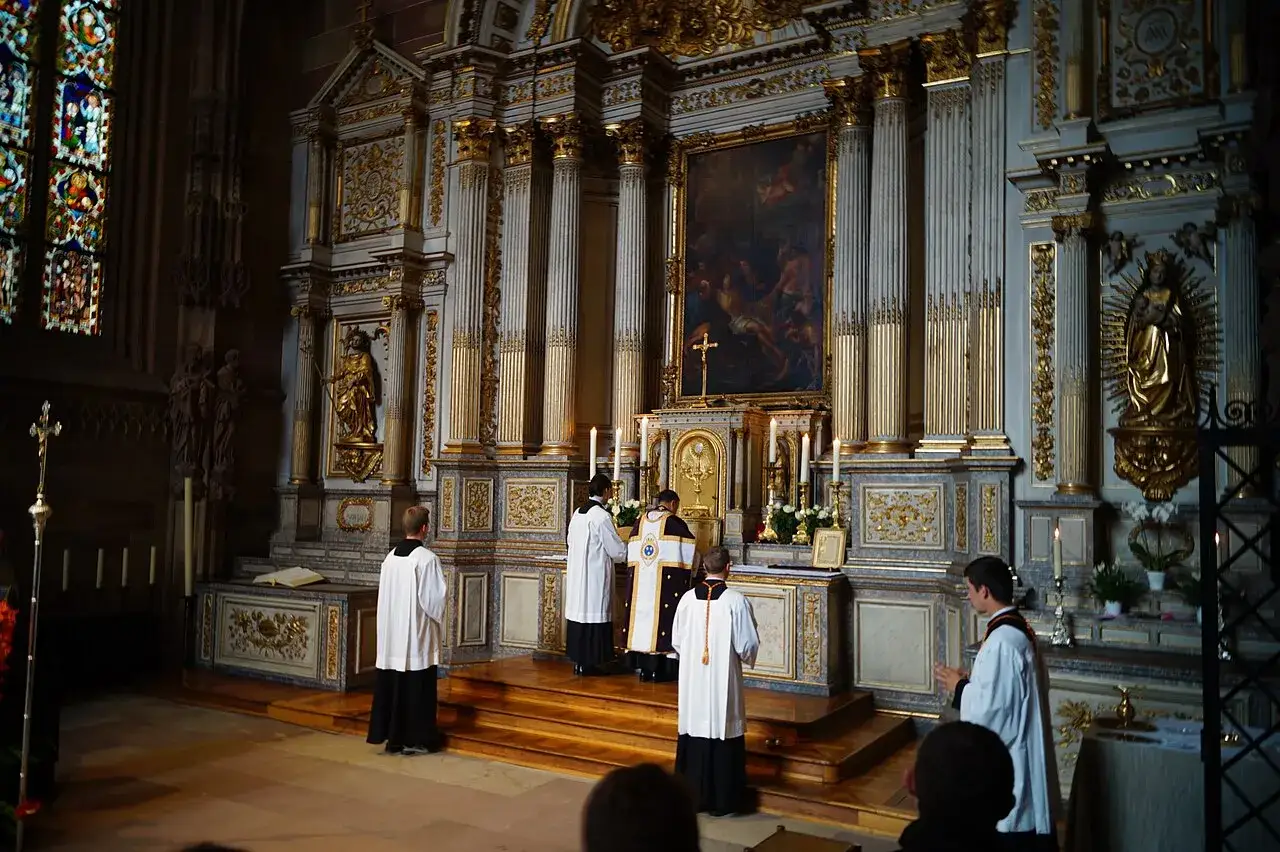 Uroczysta pierwsza modlitwa eucharystyczna w kościele. Kapłani w szatach liturgicznych przy ołtarzu.