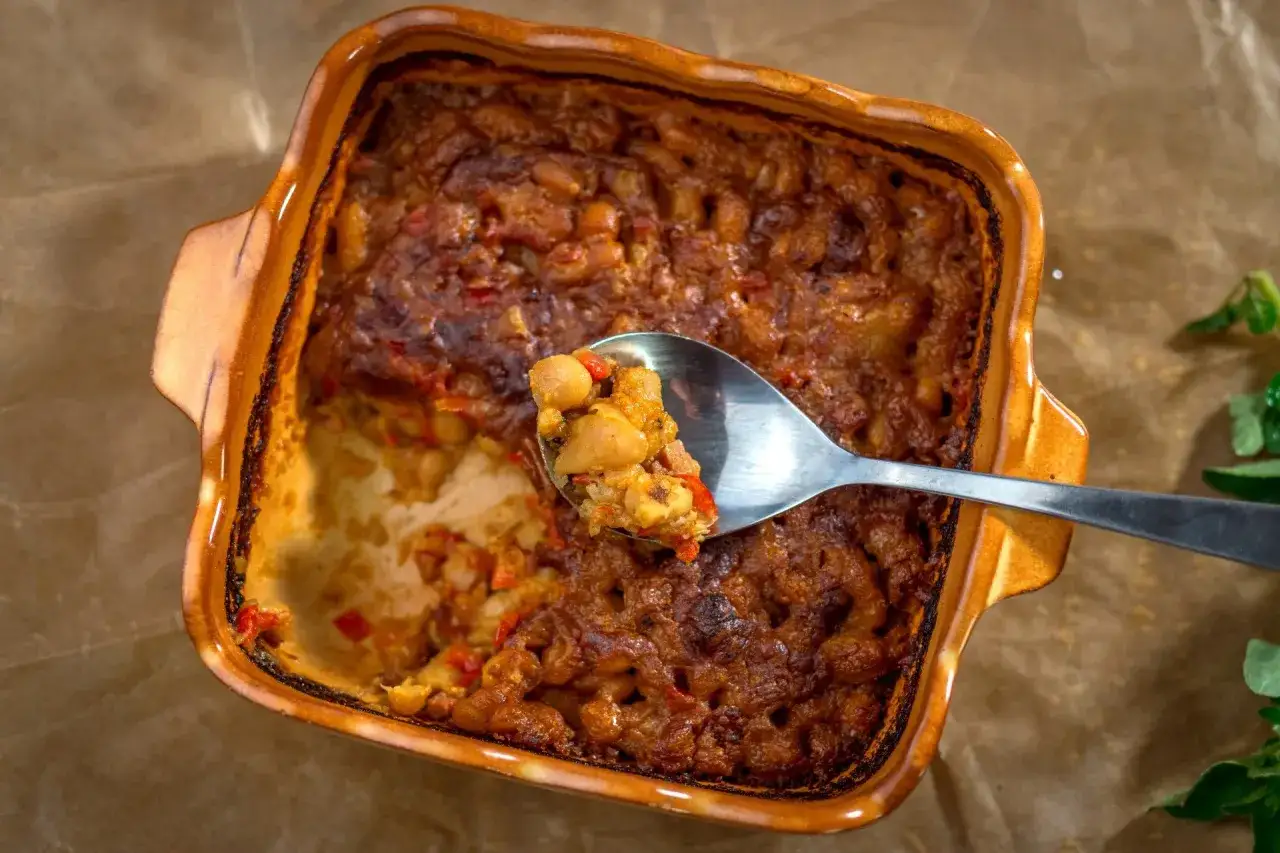 Pyszne tavce gravce, zapiekanka z ciecierzycy i fasoli, na łyżce.