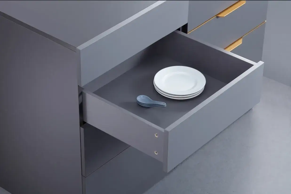 Szara szuflada z talerzami i łyżkami. Mechanizm regulacji szuflad z cichym domykiem zapewnia płynne zamykanie.