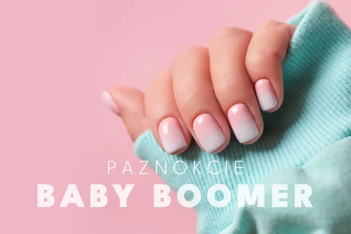 Dłoń z paznokciami hybrydowymi w stylu baby boomer, delikatny gradient różu i bieli.