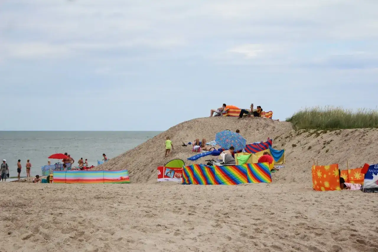Ludzie odpoczywają na piaszczystej plaży nad morzem. Czy Gdańsk jest nad morzem? Tak, to widać!