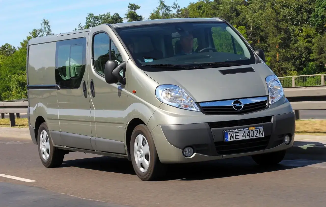Opel Vivaro w kolorze szampańskim na drodze. Kierowca i pasażer w środku. Zastanawiasz się nad opel vivaro spalanie?