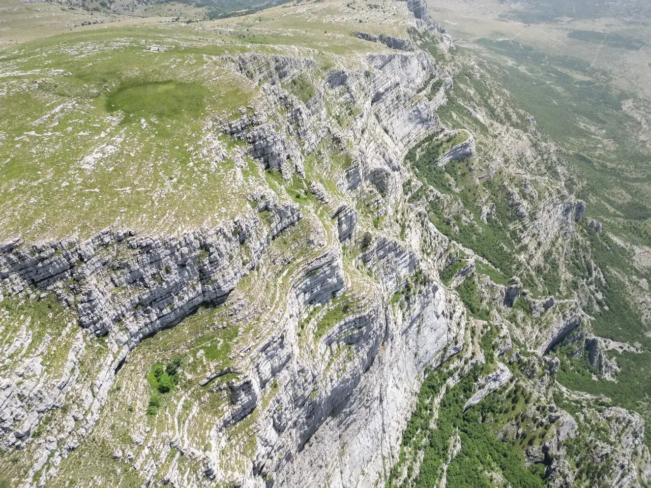 Imponujące klify i zielone zbocza gór Dinara w Chorwacji. Widok z lotu ptaka na surowy, skalisty krajobraz.