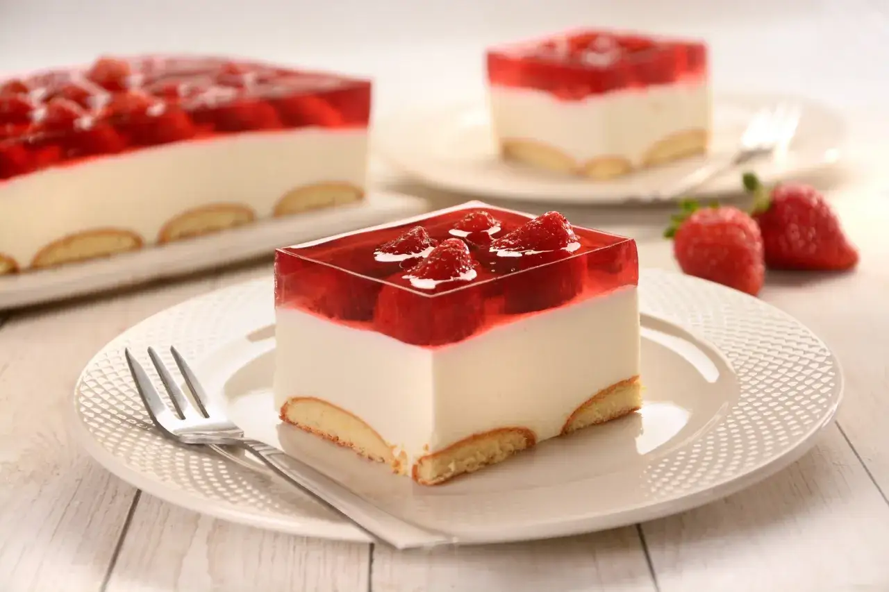 Pyszny deser z galaretką i truskawkami. Zastanawiasz się, ile czasu tężeje galaretka w lodówce, by uzyskać taką idealną konsystencję?