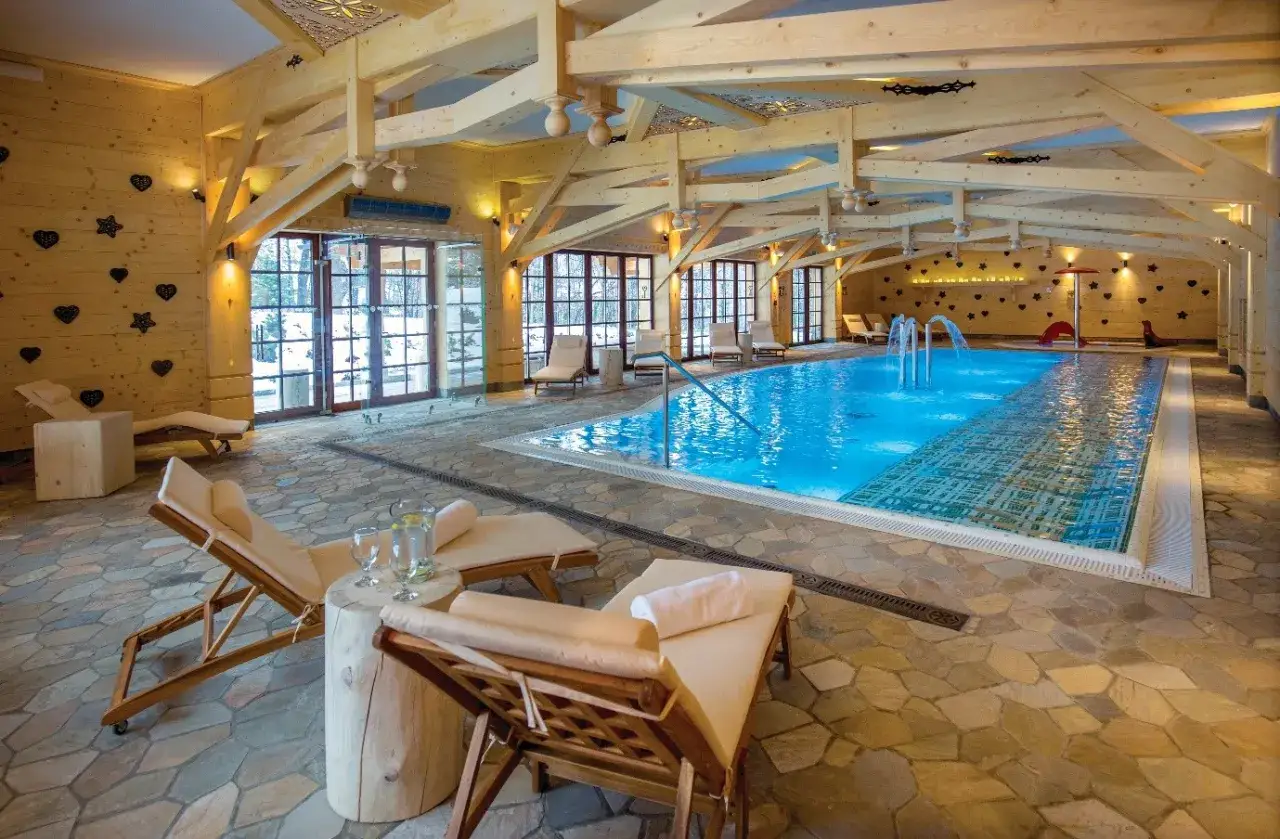 Relaks przy basenie w górskim stylu. Drewniane belki, kamienna posadzka i widok na zimowy krajobraz – to musi być najlepsze spa w Polsce.