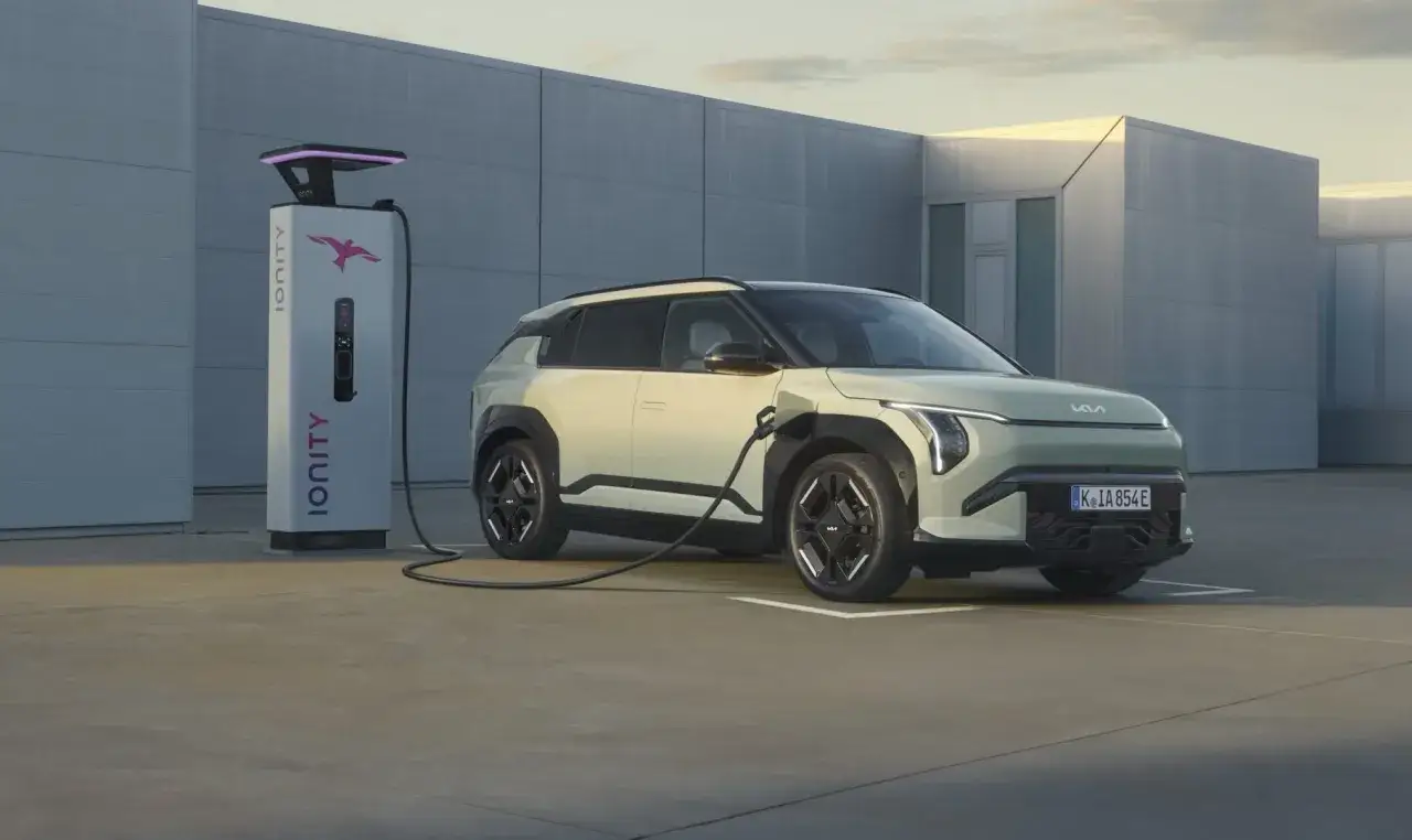 Jasnozielony samochód elektryczny Kia jest ładowany przy stacji Ionity. Obraz pokazuje, ile prądu pobiera samochód elektryczny podczas ładowania.
