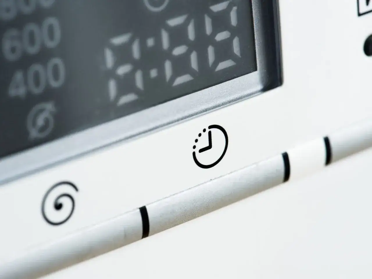 Ikona zegara na panelu urządzenia sugeruje, jak ustawić włącznik czasowy. Cyfrowy wyświetlacz pokazuje czas.