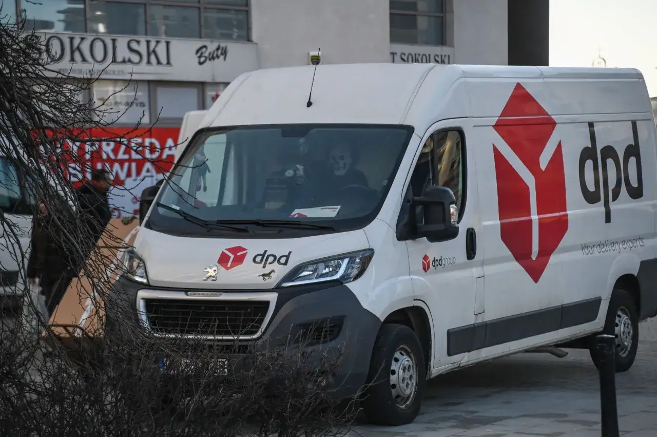 Biały van DPD z logo firmy. W kabinie siedzi kierowca w masce czaszki.