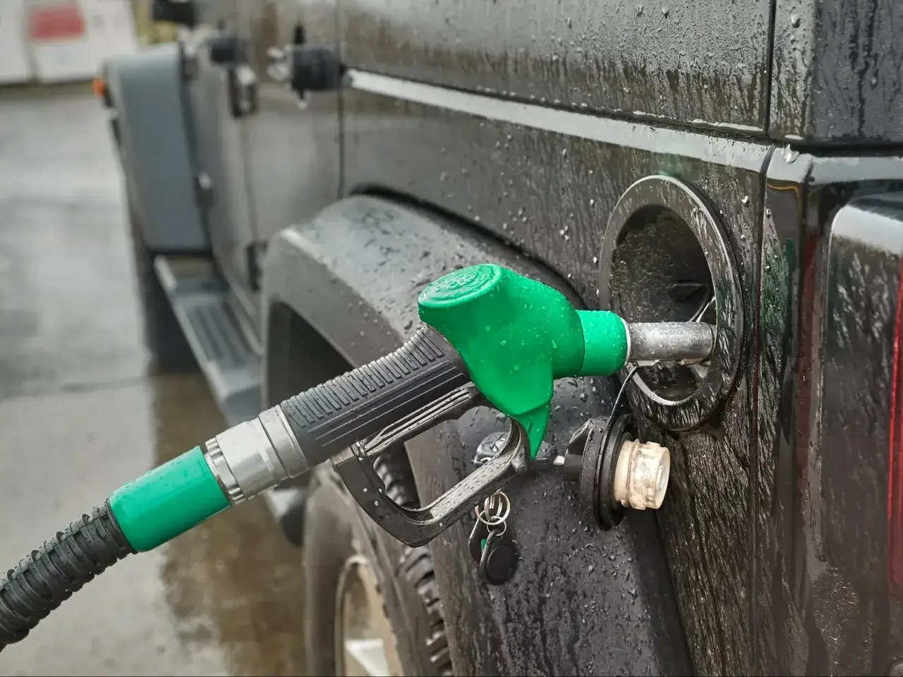 Tankowanie czarnego Jeepa w deszczu. Zastanawiasz się, ile paliwa można przewieźć przez granicę?