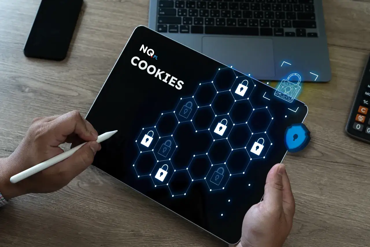 Tablet z napisem "COOKIES" i ikonami kłódek, symbolizujący jak usunąć dane przeglądarki. Obok leży telefon i kalkulator.