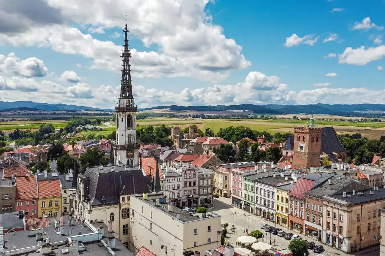 Widok z lotu ptaka na Ząbkowice Śląskie z wieżą kościelną i kolorowymi kamienicami.