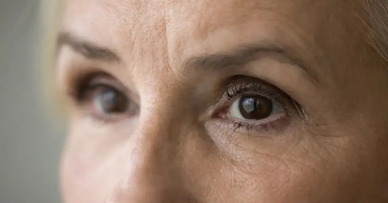 Zbliżenie na oczy dojrzałej kobiety z widocznymi zmarszczkami.