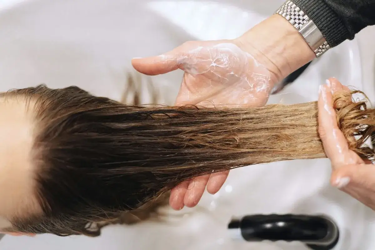 Dłonie w piance do włosów, aplikacja produktu na pasma. Czy botoks na włosy ma wady? Sprawdźmy.
