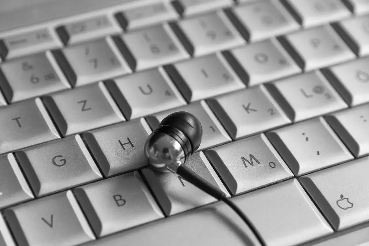 Słuchawki na klawiaturze, jakby ktoś właśnie skończył pracę na swoim pierwszym laptopie.