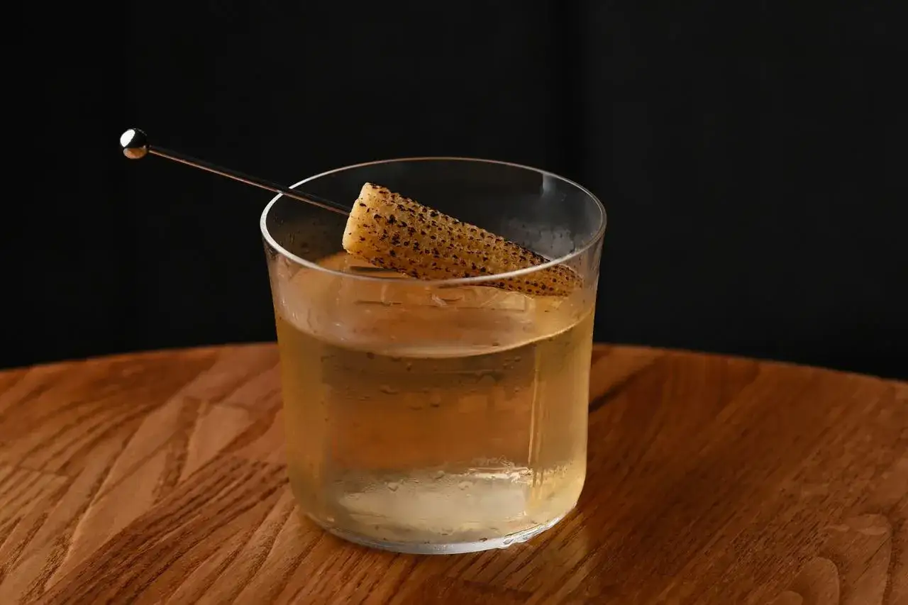 Szklanka z drinkiem i kawałkiem kukurydzy, intrygująca zapowiedź tego, jak smakuje brandy.