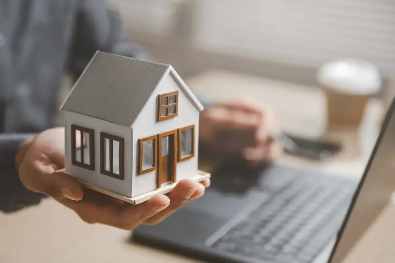 Dłoń trzymająca model domu, symbolizująca planowanie spadkowe. Kto dziedziczy po osobie niezamężnej i bezdzietnej?