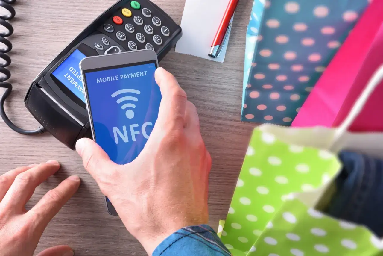 Zbliżasz telefon do terminala płatniczego, by zapłacić zbliżeniowo. To właśnie co to NFC – technologia, która ułatwia płatności mobilne.