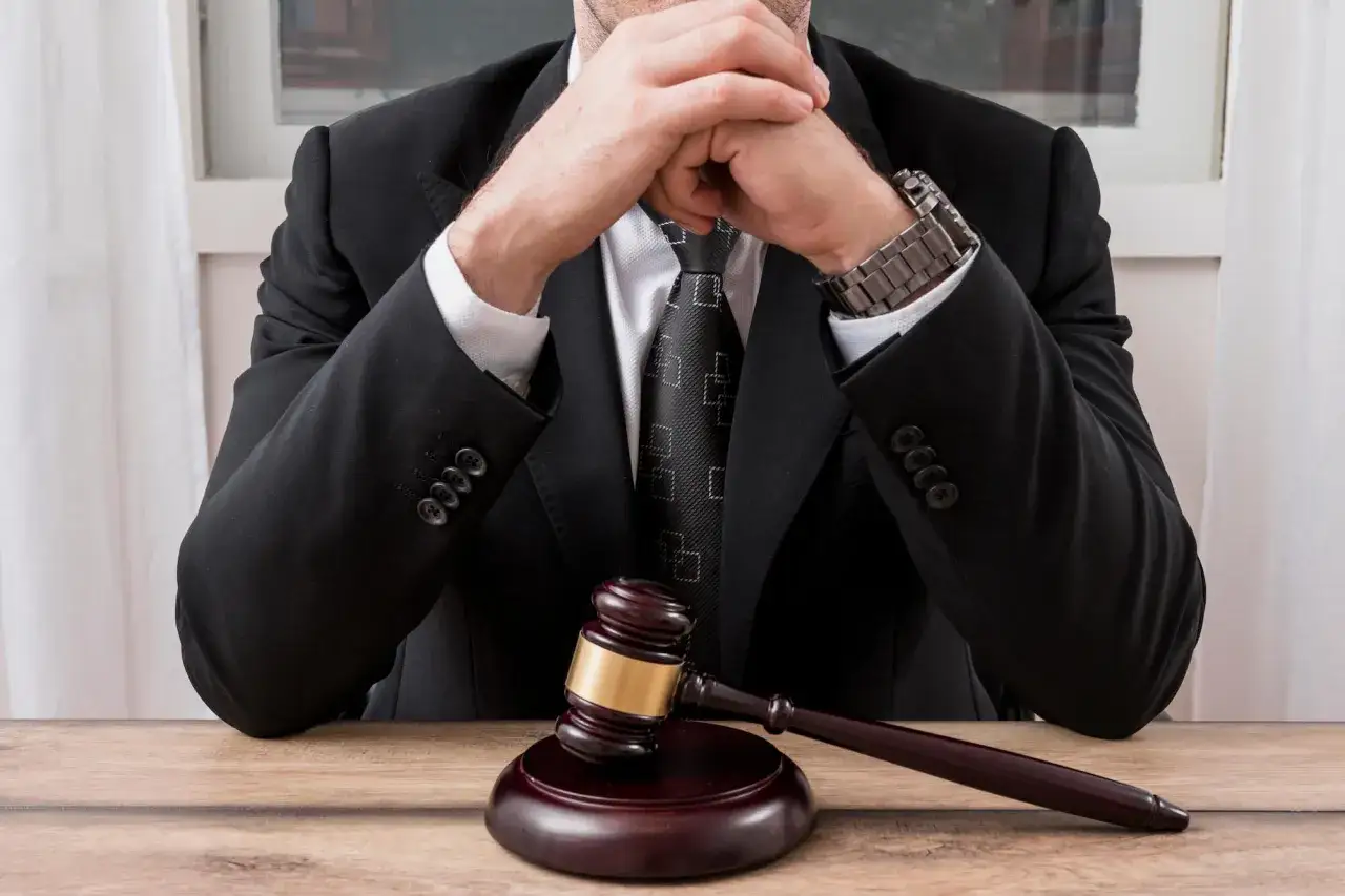 Zastanawiasz się, co zrobić, gdy adwokat nie wywiązuje się z umowy? Sędzia w garniturze z młotkiem przed sobą symbolizuje trudne decyzje.