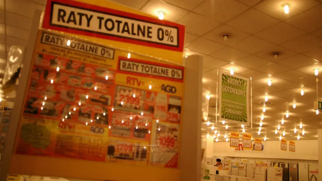 Plakat z napisem "RATY TOTALNE 0%" i ofertami RTV EURO AGD w sklepie.