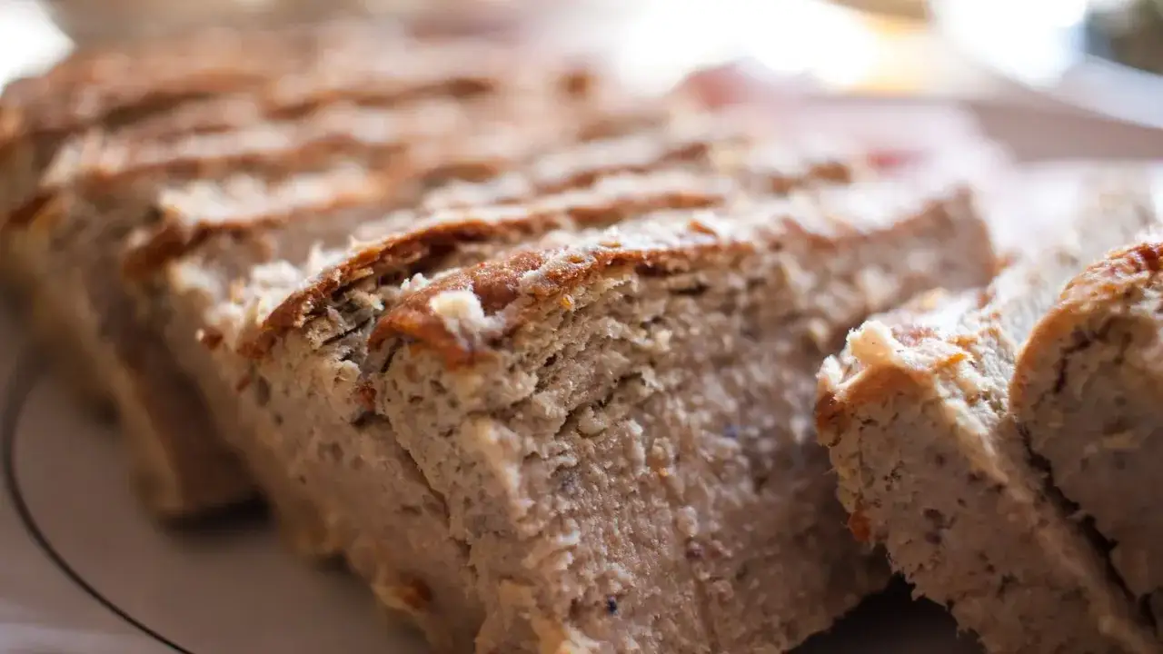 Pokrojony pasztet drobiowy z chrupiącą skórką, ułożony na talerzu.