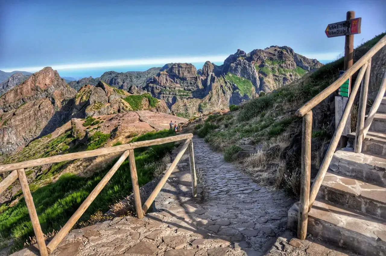 Kamienista ścieżka prowadzi przez górzysty krajobraz Madery, oferując widok na skaliste szczyty i ocean. To jedne z najpiękniejszych szlaków trekkingowych na Maderze, łączące lewady i szczyty.